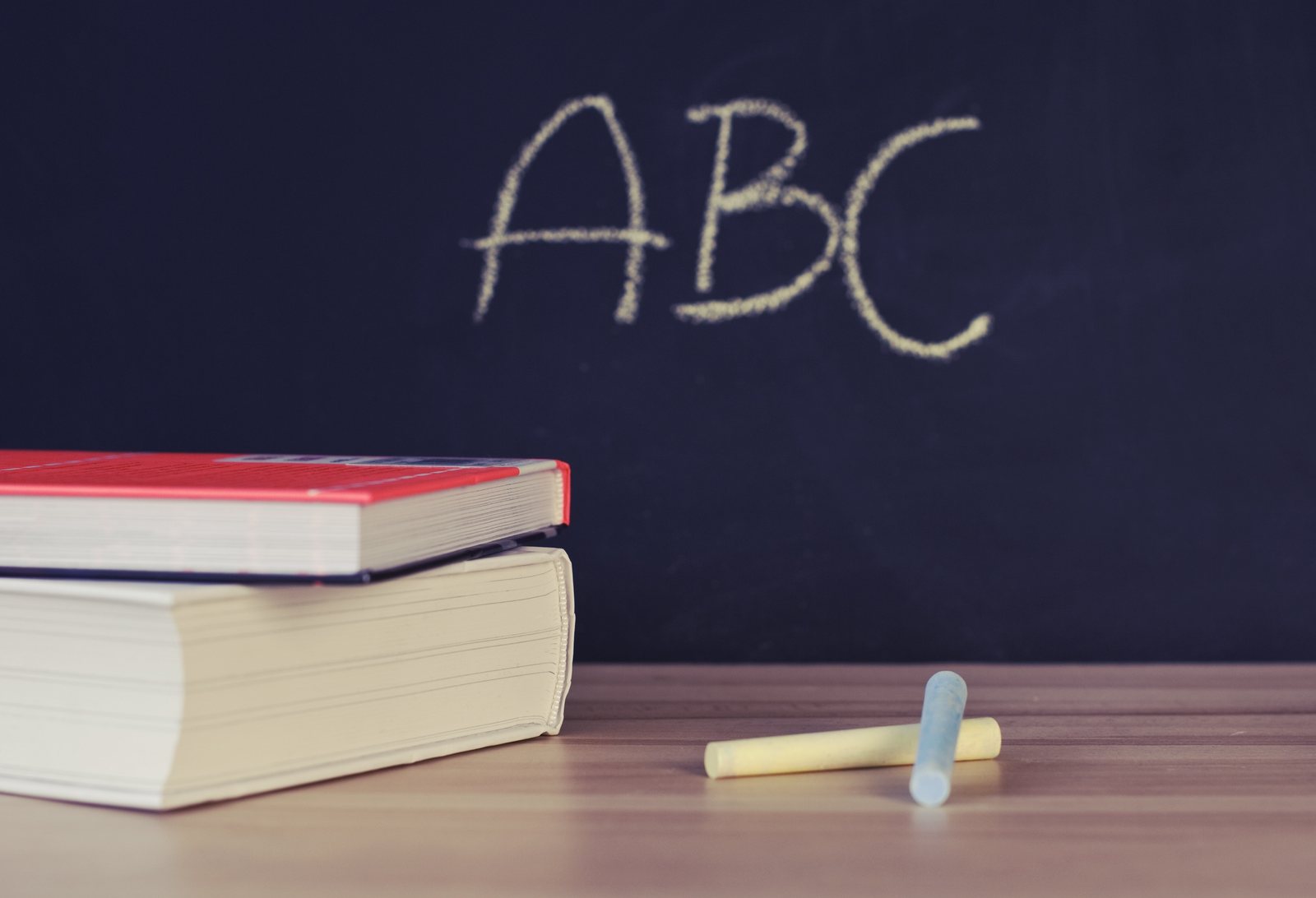 Schultafel mit ABC, Bücherstapel und Kreide — Mediation in der Schule